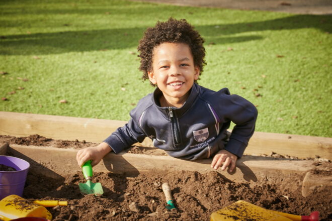 Nursery pupil digging in a garden bed